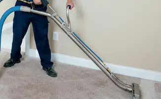 Professional operating a liquid removal machine on a carpeted floor in Pueblo, CO